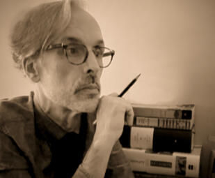 A man in eyeglasses with a stack of books